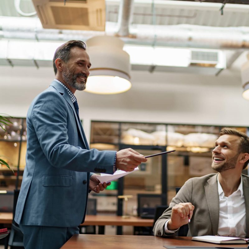 mature business coach or speaker make flip chart presentation to diverse businesspeople at meeting